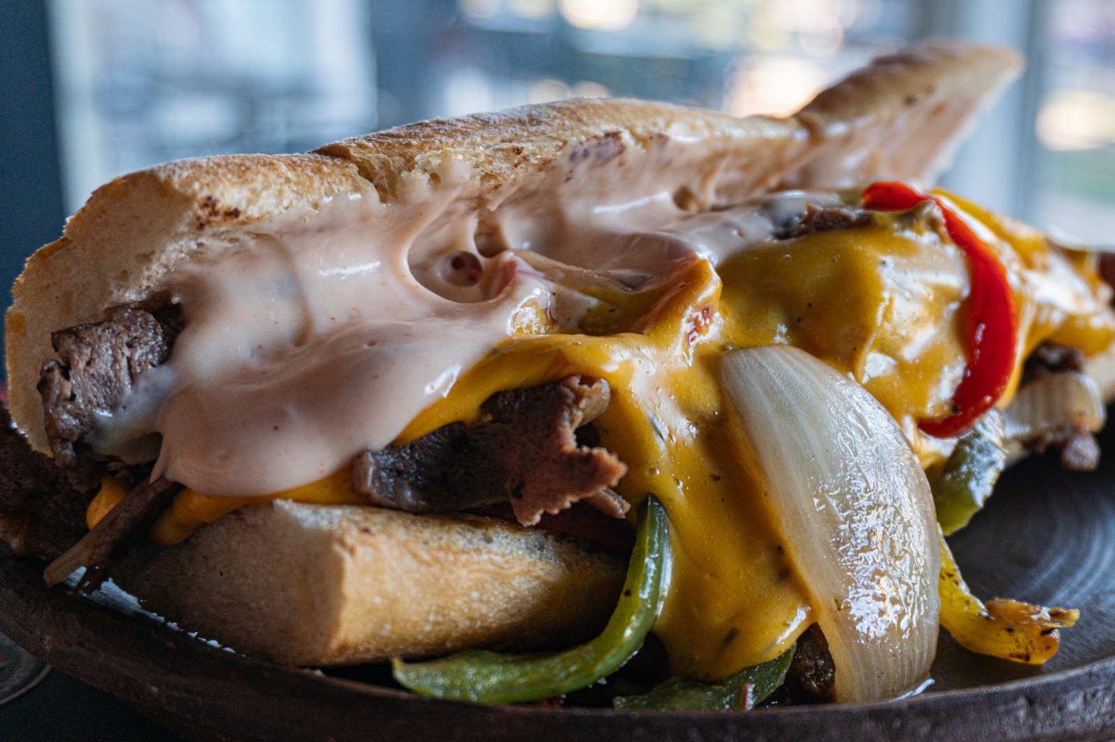 Filadelfia Clásico — Churrasco sazonado, salteado de pimentón y cebolla, queso fundido y salsa chedda