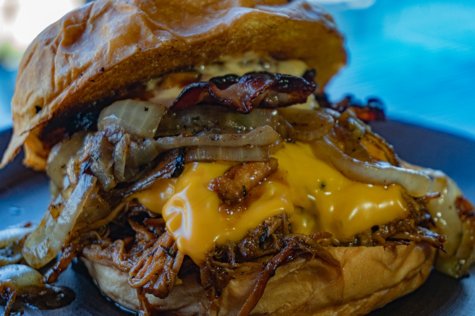 Smoke Texas — Pulled pork, queso cheddar, tocino y cebolla asada, con salsa ahumada de BBQ.